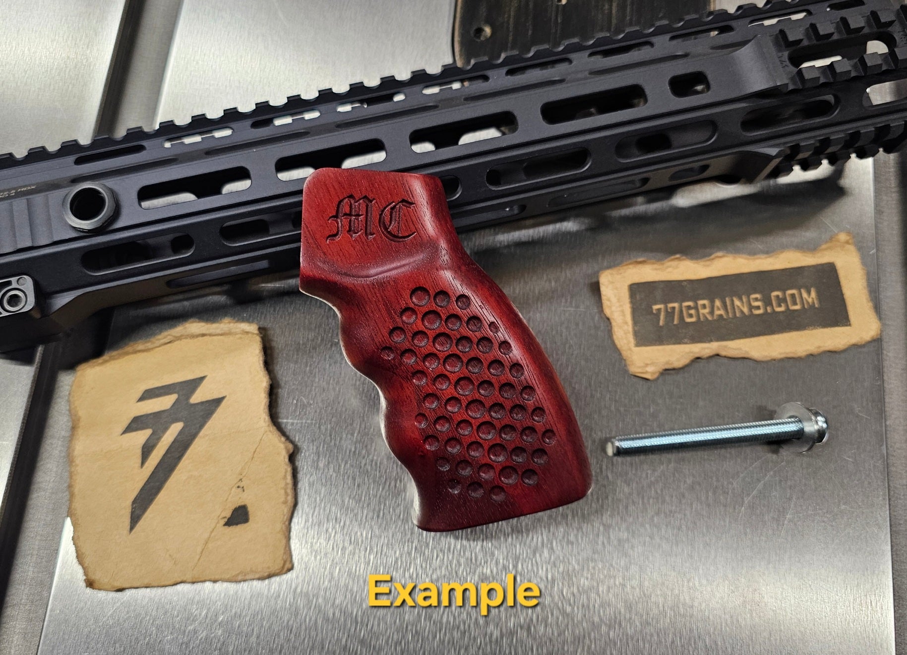 Wooden ar15 gun grip with text on a metallic surface
